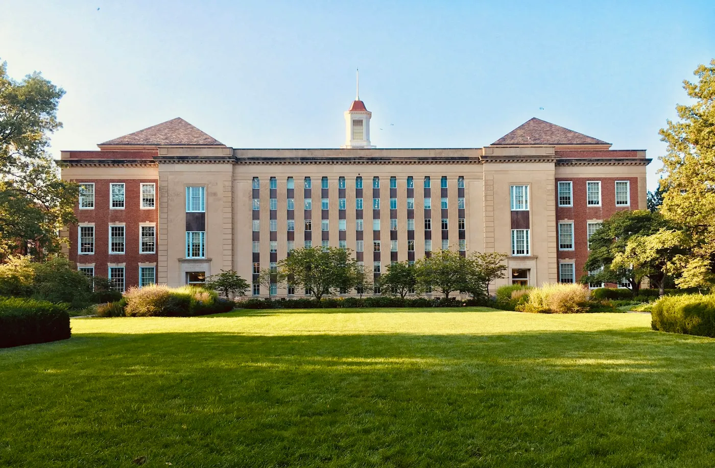 A university building behind a clipped lawn