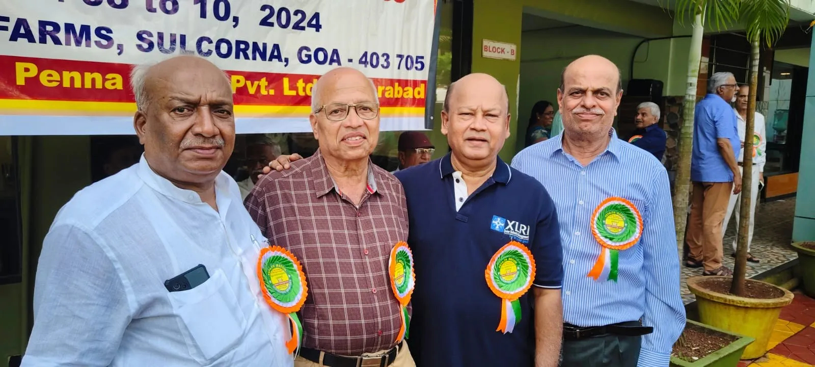 Members wearing rosettes at an event in Goa